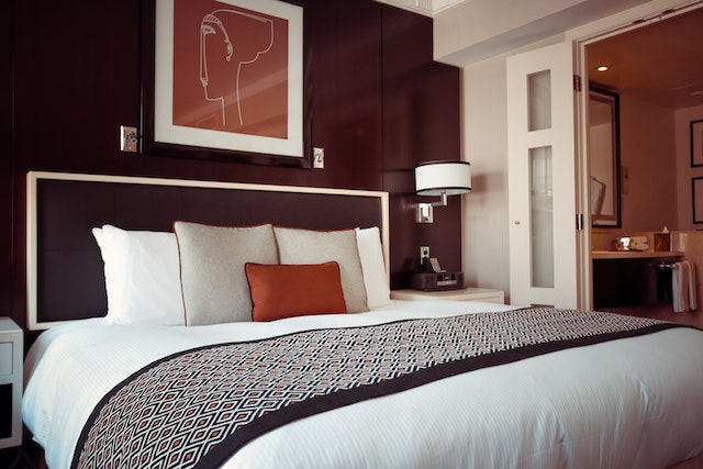 A hotel room with a modern and distinctive design, in luxurious and comfortable colors, with a picture hanging on the wall.